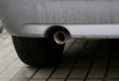 Closeup of a rear car exhaust pipe situated in a car's exhaust system