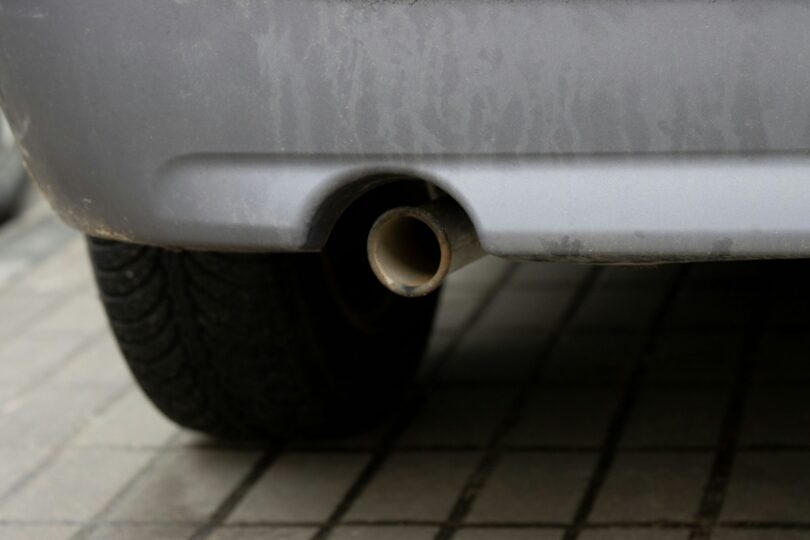 Closeup of a rear car exhaust pipe situated in a car's exhaust system