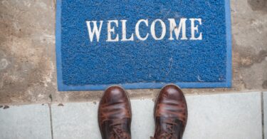 Welcome mat on ground with person standing next to it
