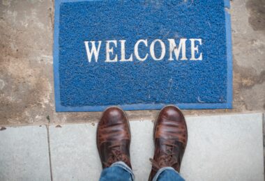 Welcome mat on ground with person standing next to it
