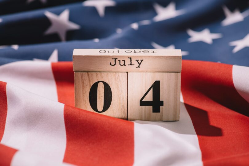 close up view of wooden calendar with 4th july date on american flag, americas independence day