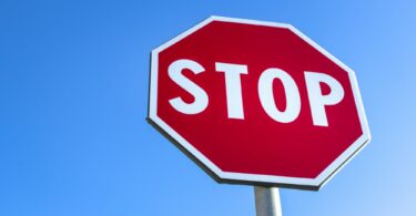 Red stop road sign and blue sky