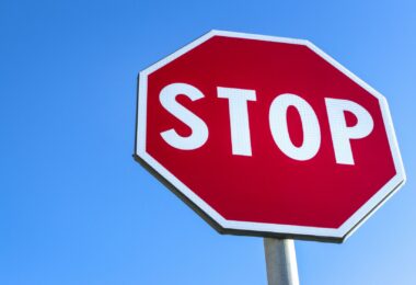 Red stop road sign and blue sky