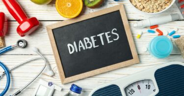 Word Diabetes and diabetic accessories on wooden background