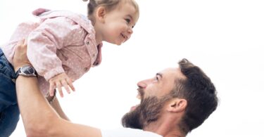 Young dad and little daughter playing outdoors