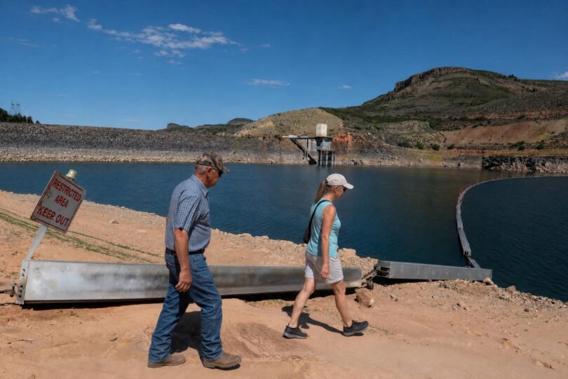 Low Colorado reservoir shoreline with exposed banks under a wide sky
